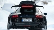 Вид сзади на черный Audi R8 среди снежных сугробов